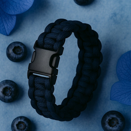 Black braided bracelet with a metal buckle on a blue background with blueberries